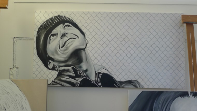 Portrait painting of a man in a knit cap with a knowing grin, by Kim Parrent